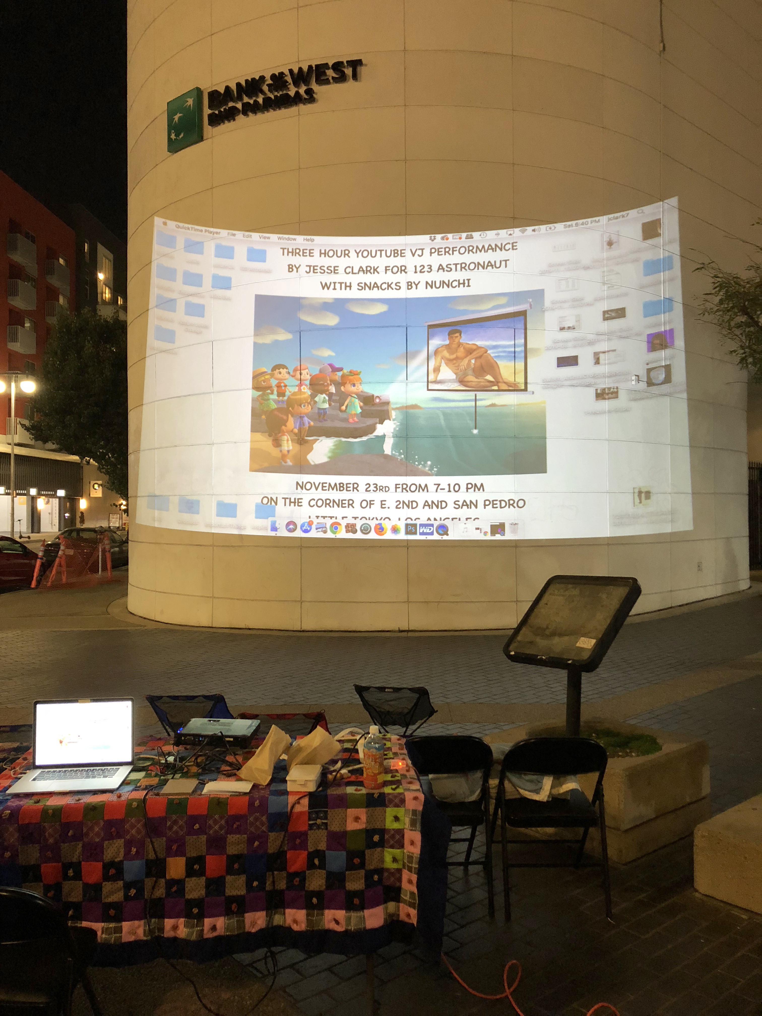A building with a projection on a it behind a table with a laptop connected